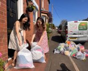 Two women placing bags of donated clothes at their front door for a free We Recycle Clothes collection in Nottingham